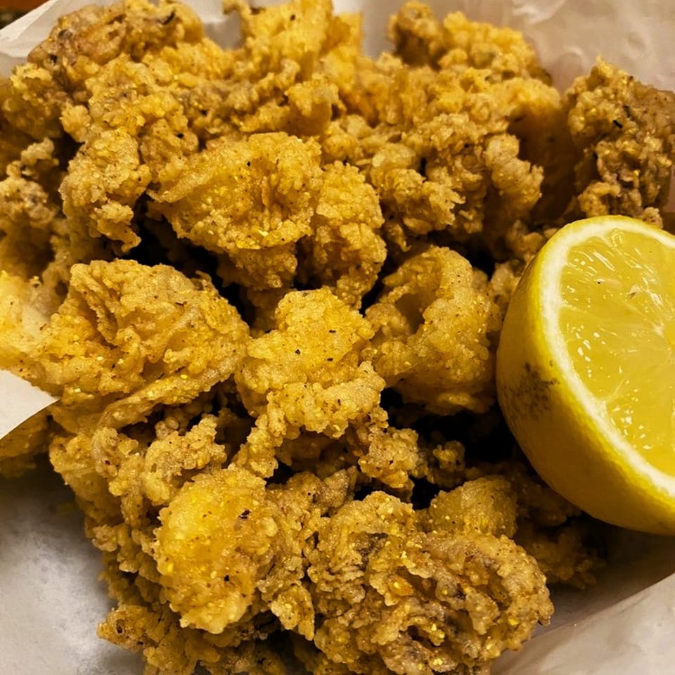 Crispy fried calamari with a lemon wedge, a classic Italian appetizer from Viva Italiano Pizzeria.