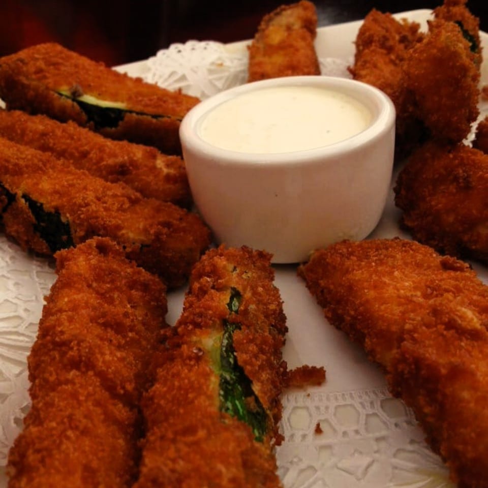 Viva Italiano Pizzeria's crispy fried zucchini sticks with a side of creamy dipping sauce.